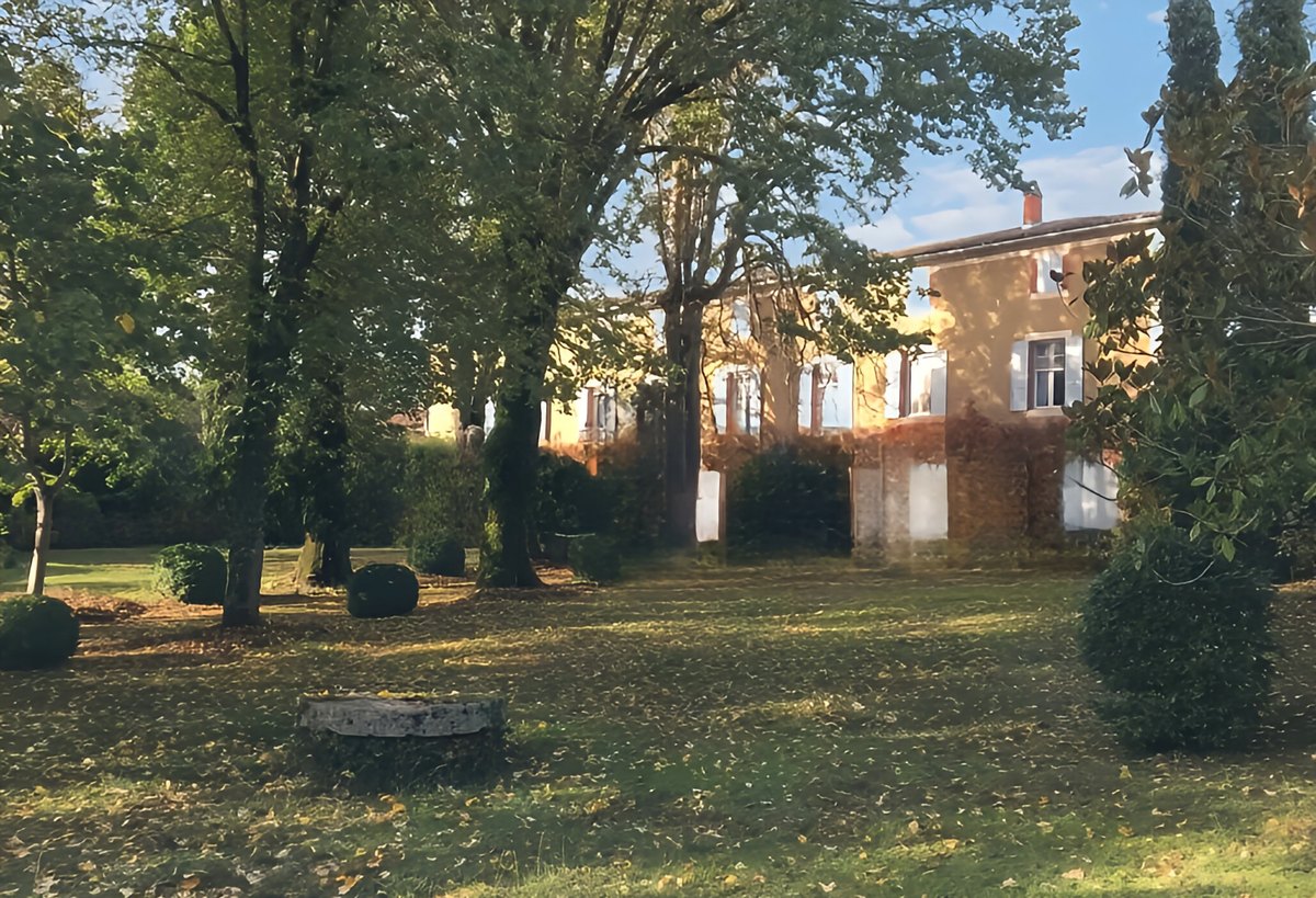 Le parc en fin de journée : grands arbres, pelouse jonchée de feuilles, la maison au second plan